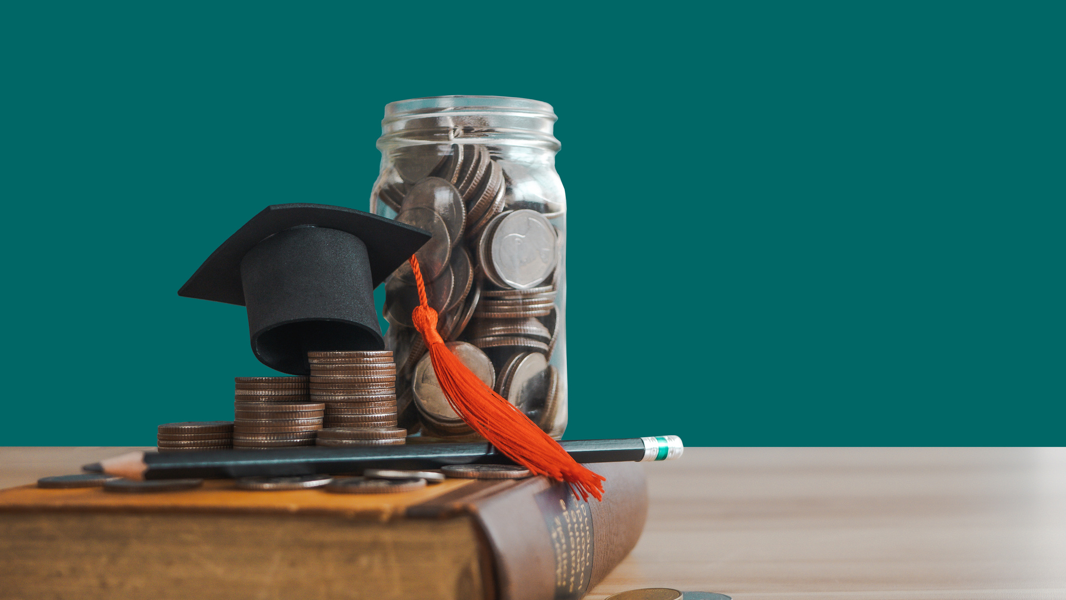 A graduation cap on money coins saving for concept investment education and scholarships. Ideas for College and University Tuition Fees for education. a scholarship that grows through success.